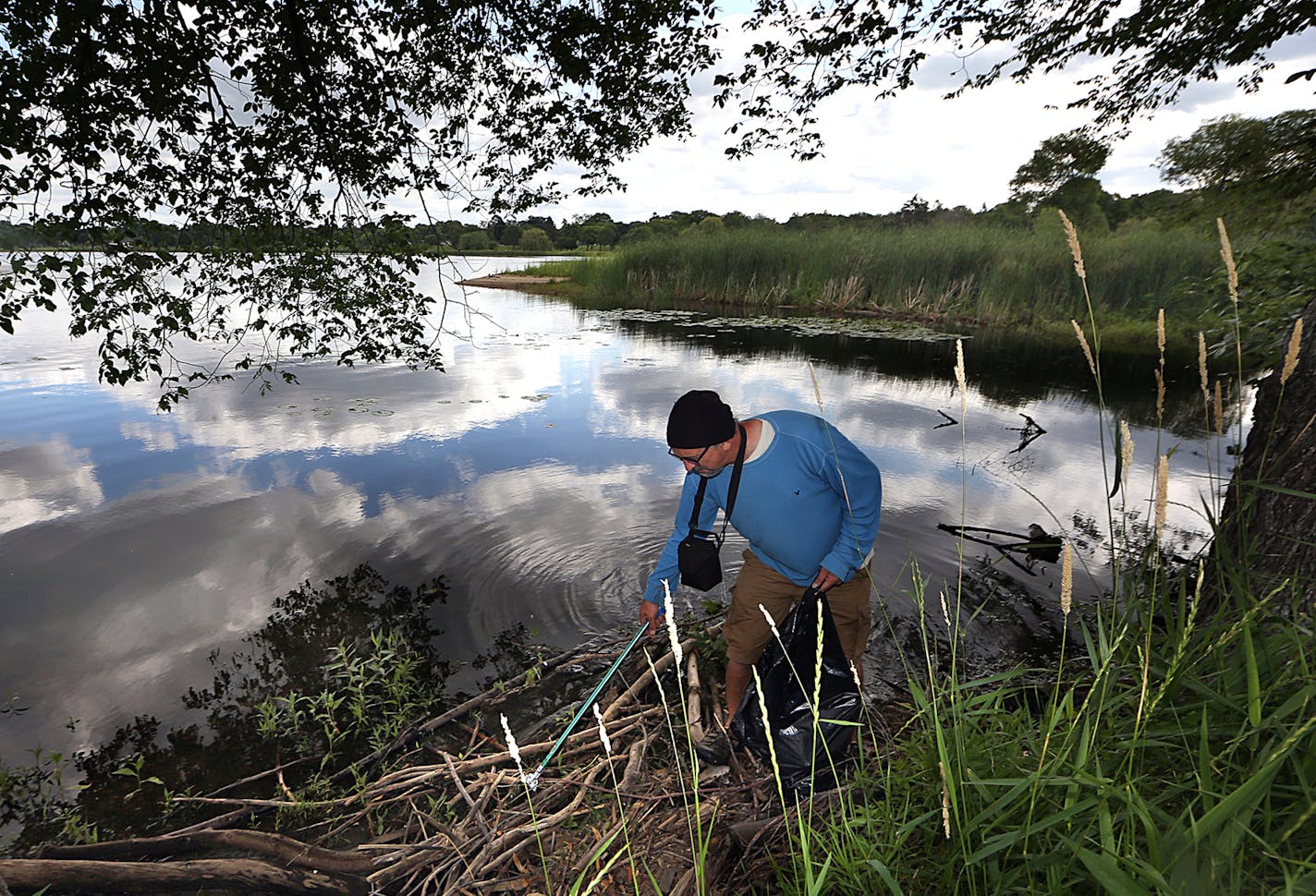 Sean Connaughty collected trash along the shore of Lake Hiawatha, near the Hiawatha Golf Course. ] JIM GEHRZ &#xd4; james.gehrz@startribune.com / Minneapolis, MN / July 8, 2015 / 9:30 AM &#xd2; BACKGROUND INFORMATION: Sean Connaughty has collected more than 1,500 pounds of garbage from Lake Hiawatha. He is still collecting, and he is presenting a plan to the Minnehaha Creek Watershed District Tuesday on how to stop trash from entering the lake. He has the community involved. In September, he is