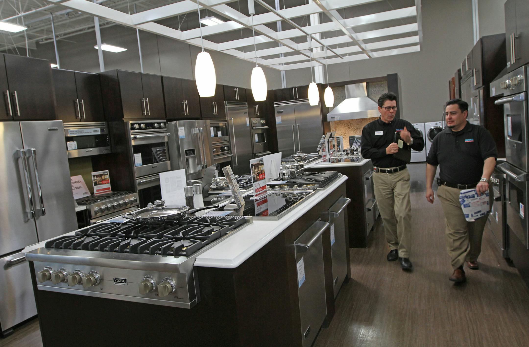 (left to right) Pacific Kitchen Staff Members Billy Woodson and Hector Saenz High walked past high end appliances on display at the Best Buy Pacific Kitchen display at the Richfield MN., store on 3/6/13. Best Buy's appliance business has shown strong growth, one of the few product categories where comp sales have increased. At the company's next generation Connected Store, Best Buy has devoted quite a bit of space to its high end Pacific Kitchen brand.] Bruce Bisping/Star Tribune bbisping@startr