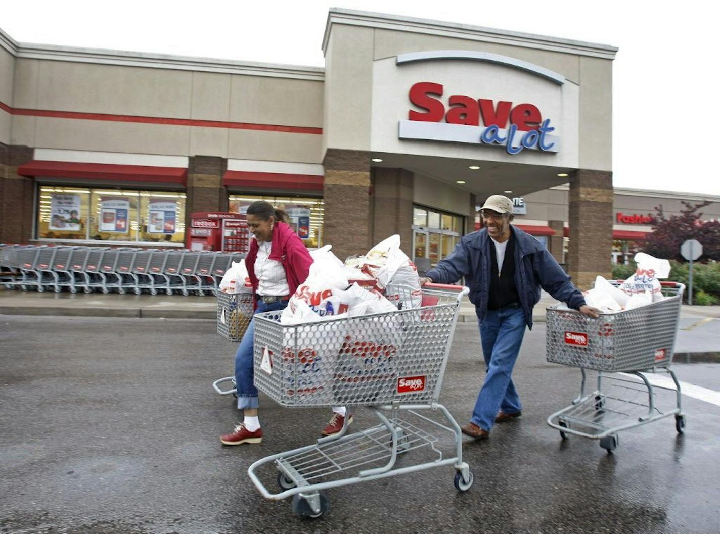 Shoppers Camelious Thompson and her brother Mark Eaton leave a Save-A-Lot store in St. Louis, Missouri, U.S., on Thursday, May 20, 2010.