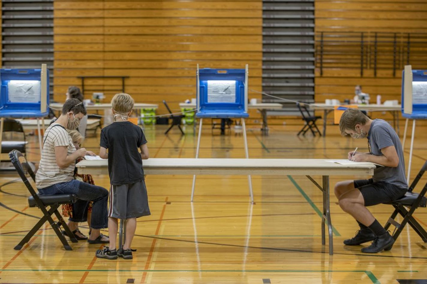 Nora Jenneman and Ryan Seibold voted as their children Fern Seibold, 5 and Rainer Seibold, 10 looked on at the Roosevelt High School polling location, Tuesday, August 11, 2020 in Minneapolis, MN.