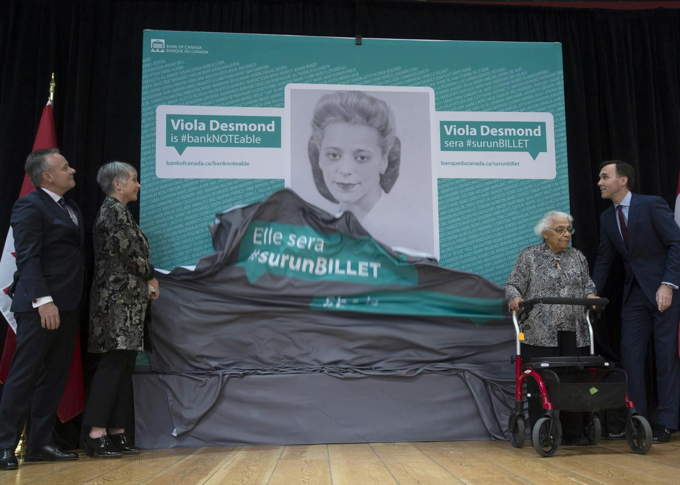 Bank of Canada Governor Stephen Poloz, left, Minister of Status of Women Patricia Hajdu, Minister of Finance Bill Morneau, right, and Wanda Robson unveil an image of Viola Desmond who will be featured on the new Canadian ten dollar bill during a ceremony in Gatineau, Quebec, Canada Thursday Dec. 8, 2016. Robson is Viola Desmond's sister. (Adrian Wyld/The Canadian Press via AP)