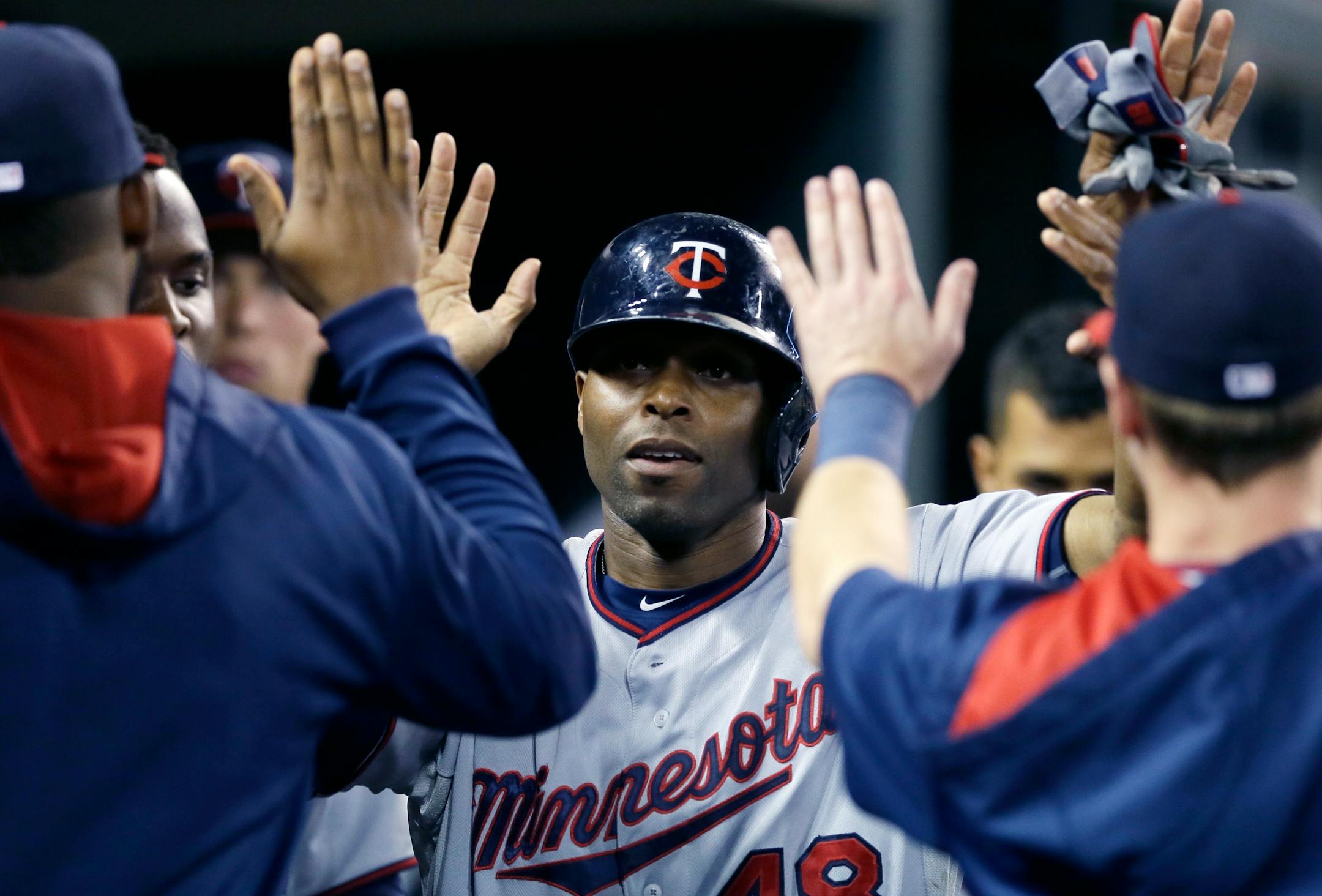 Minnesota Twins' Torii Hunter is congratulated after scoring during the seventh inning of a baseball game against the Detroit Tigers, Saturday, Sept. 26, 2015 in Detroit. (AP Photo/Carlos Osorio)