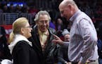Los Angeles Kings owner Phil Anschutz, center, and his wife Nancy, left, talk with Los Angeles Clippers owner Steve Ballmer during the first half of a