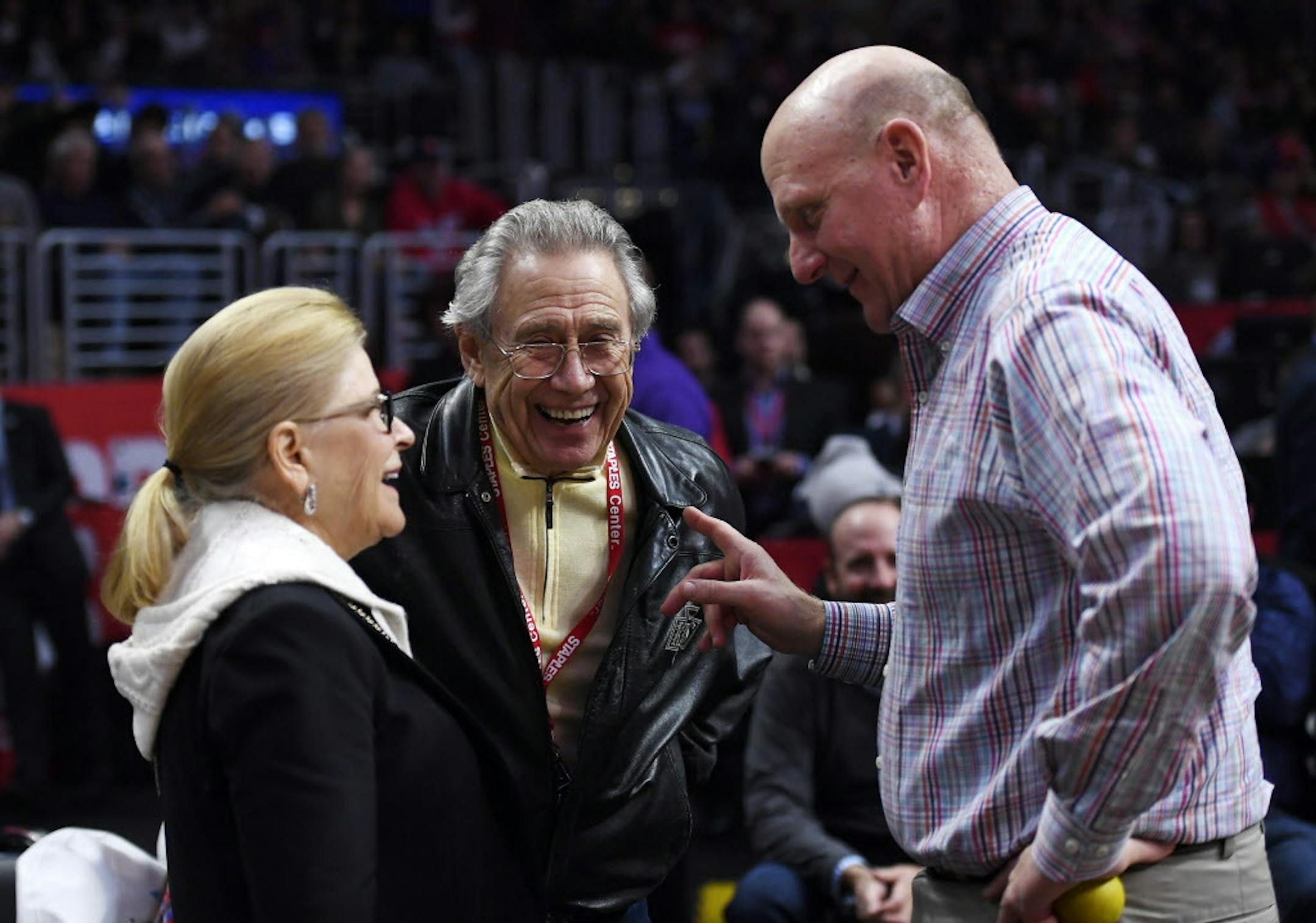 Los Angeles Kings owner Phil Anschutz, center, and his wife Nancy, left, talk with Los Angeles Clippers owner Steve Ballmer during the first half of an NBA basketball game between the Clippers and the Orlando Magic, Wednesday, Jan. 11, 2017, in Los Angeles. (AP Photo/Mark J. Terrill)