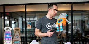 DeLonn Crosby, inventor of the ToyBot, spoke into the plush robot’s chest as his family helped assemble and box the various toys at their working sp