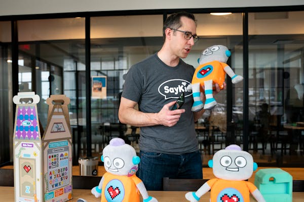 DeLonn Crosby, inventor of the ToyBot, spoke into the plush robot’s chest as his family helped assemble and box the various toys at their working sp
