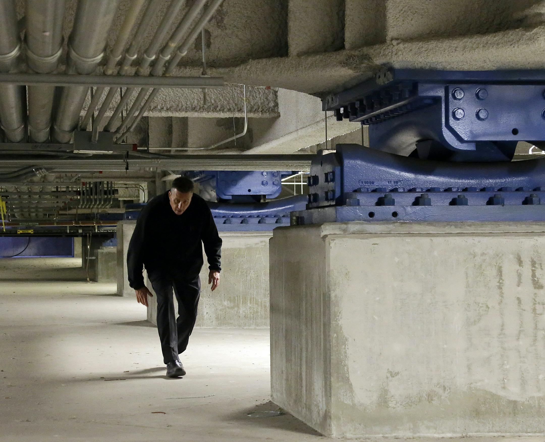 In this Jan. 14, 2014 photo, Los Angeles Emergency Management Coordinator and Public Information Officer Hans Christian Ipsen ducks under low hanging pipes next to friction pendulum bearings which support the Los Angeles city Emergency Operations Center in downtown, where dozens of specialists would report to handle a major emergency. The Jan. 17, 1994 Northridge earthquake was felt over a broad area of Southern California, causing widespread death and destruction. While the state has made strid
