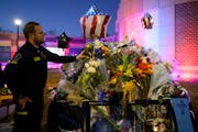 Eric Heuer, district chief with North Memorial Ambulance, places flowers on a squad car of a fallen police officer on Feb. 20 outside the Burnsville P