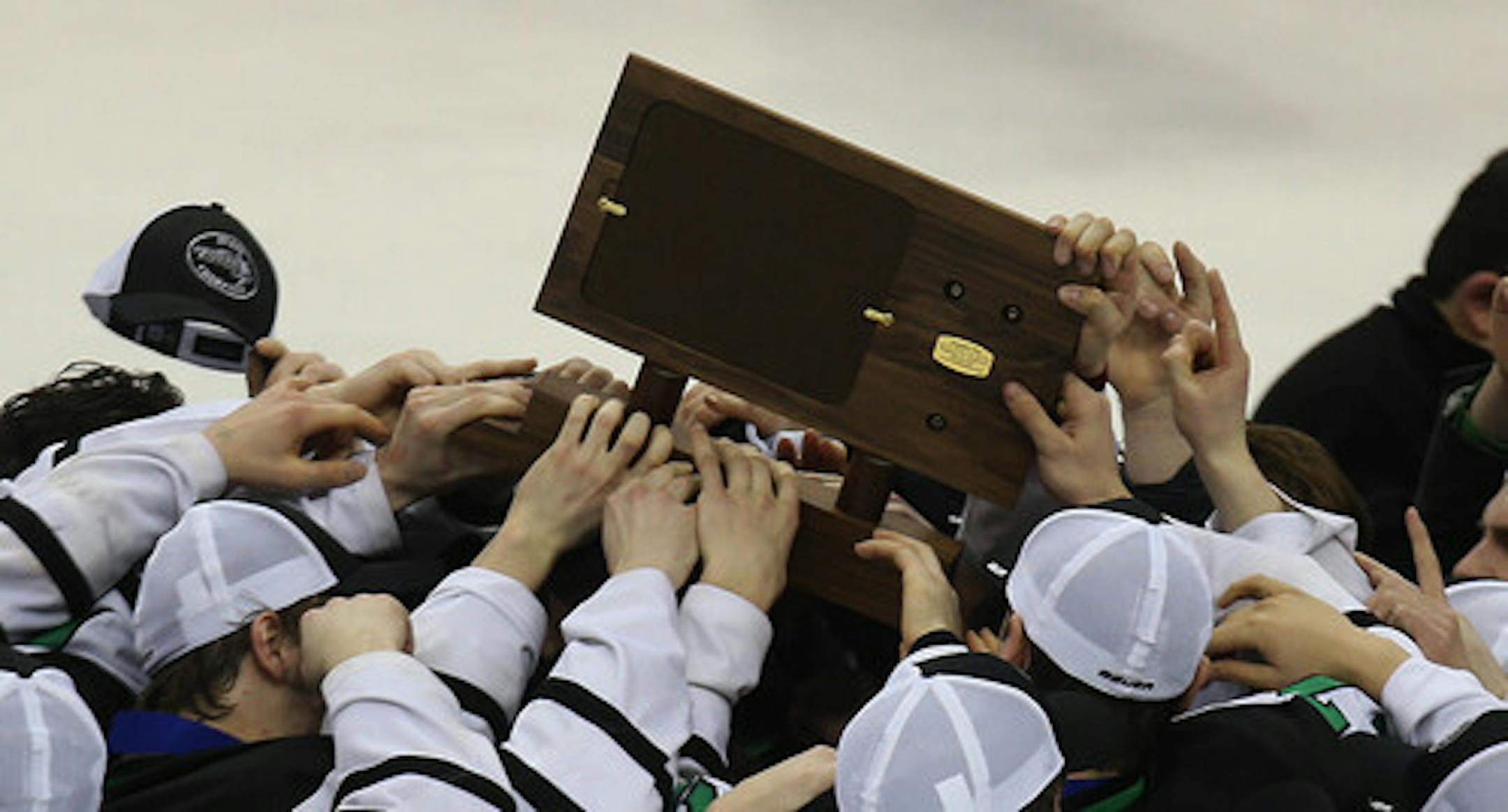 Members of the East Grand Forks team carried the Class A championship trophy. ] JIM GEHRZ • jgehrz @startribune.com / St. Paul, MN / March 8 , 2014 / 12:00 PM  BACKGROUND INFORMATION: East Grand Forks High School played Hermantown in  the Class 1A championship game of the 2014 Boy's State Hockey Tournament at the Xcel Energy Center. ORG XMIT: MIN1403081542493030 ORG XMIT: MIN1803062018425509