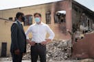 Minneapolis Mayor Jacob Frey and St. Paul Mayor Melvin Carter talk in a Lake Street parking lot by a building damaged in the unrest after George Floyd