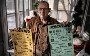 Norm Kietzer with wrestling promotional posters he created.