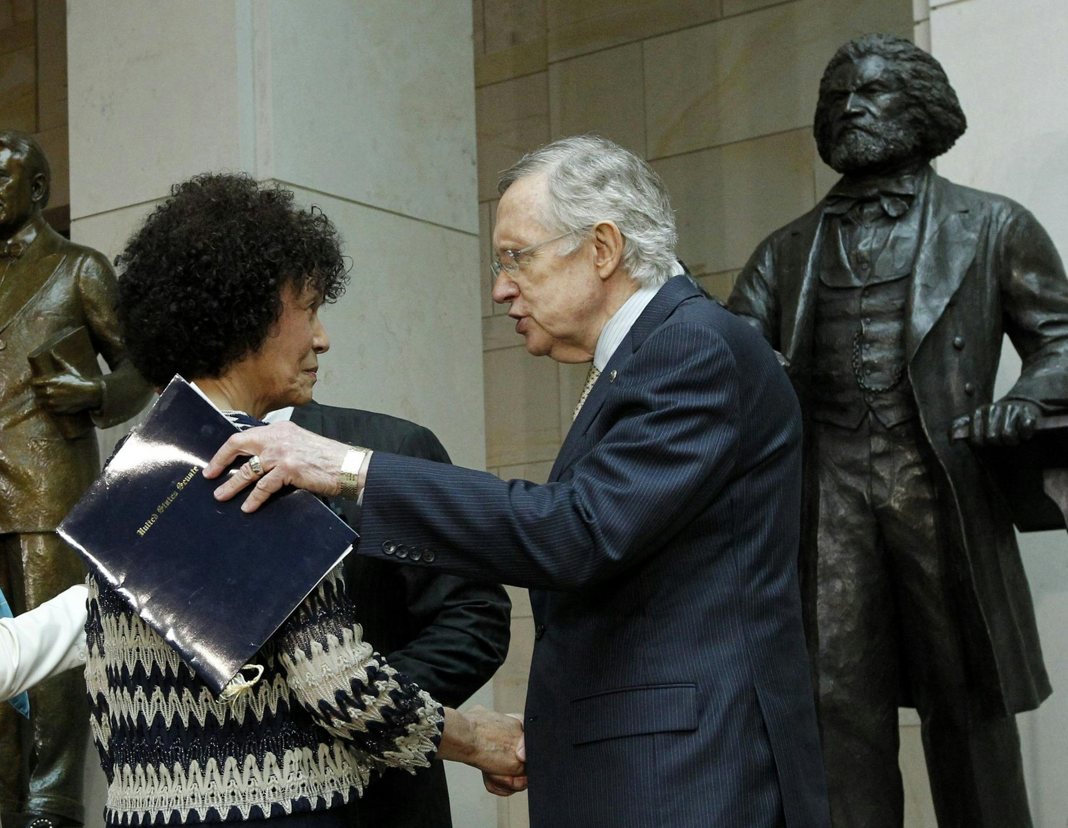 Senate Majority Leader Harry Reid greets Nettie Washington Douglass, descendant of Frederick Douglass, after a ceremony honoring Frederick Douglas next to his statue inside the U.S. Capitol in Washington June 19, 2013. (Molly Riley/MCT)