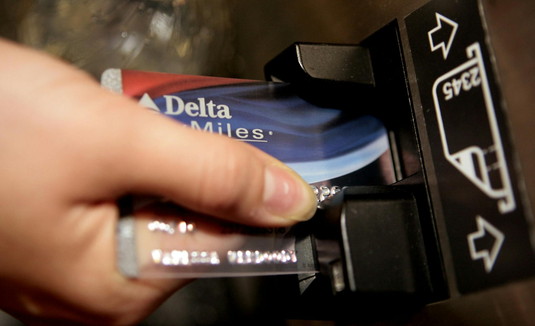 FILE - In this Dec. 14, 2007 file photo, a traveler uses a Delta SkyMiles credit card to buy an airline e-ticket at the Bob Hope Airport in Burbank, Calif. Delta Air Lines Inc. said Wednesday, May 5, 2010, it will waive the first checked-bag fee for customers who have a Delta SkyMiles Credit Card.(AP Photo/Damian Dovarganes, File)