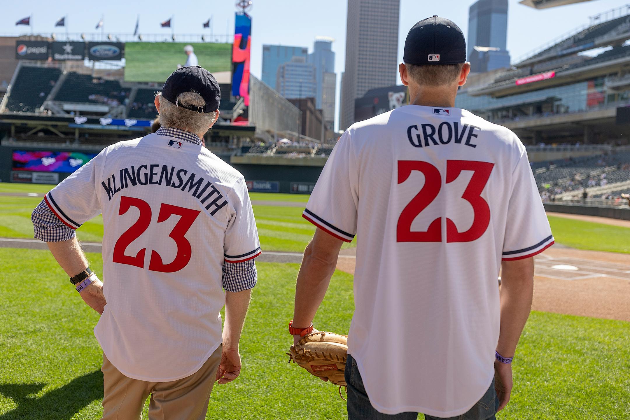 Retiring Star Tribune publisher Mike Klingensmith and incoming publisher Steve Grove stand at the edge of the infield before Klingensmith threw out the ceremonial first pitch, with Grove catching.