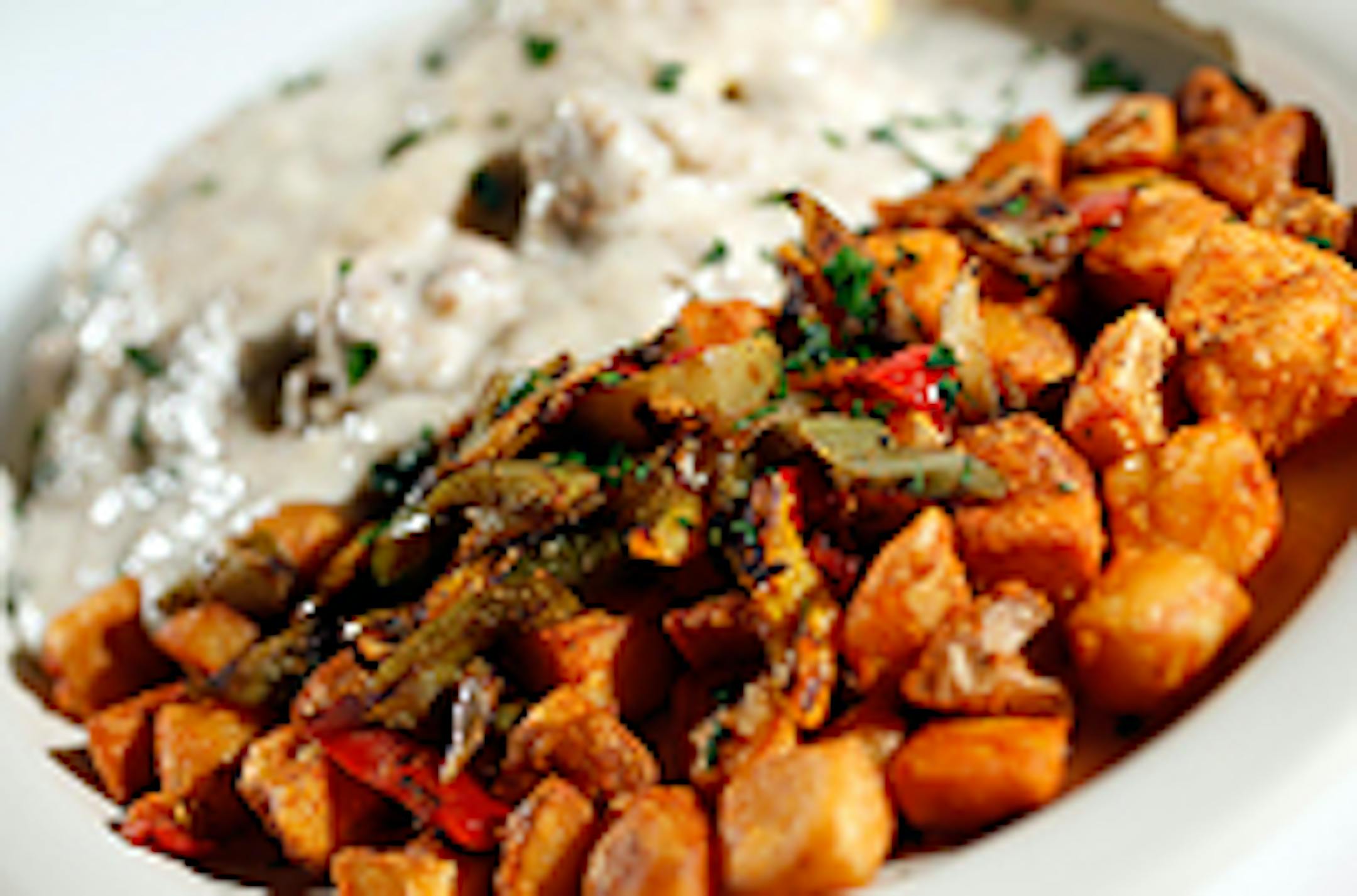 The Country Benedict at The CC Club in Minneapolis: two biscuits, two sausage patties, three scrambled eggs, sausage gravy and home fries.