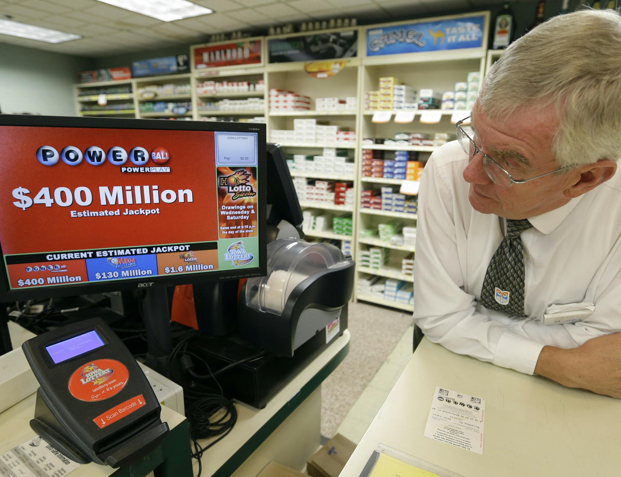 Dahl's grocery store manager Don Mark looks at a monitor displaying the estimated jackpot amount for Wednesday's Powerball drawing, Tuesday, Sept. 17, 2013, in Des Moines, Iowa. The giant Powerball jackpots keep coming, with the latest $400 million prize ranking among the largest ever. But soon, lottery players could see even more huge jackpots as organizers of the Mega Millions lottery move ahead with plans to revamp the game and attract more players. (AP Photo/Charlie Neibergall)