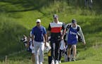 Tiger Woods, left, and Brooks Koepka walk to the 14th fairway during the first round of the PGA Championship golf tournament, Thursday, May 16, 2019, 