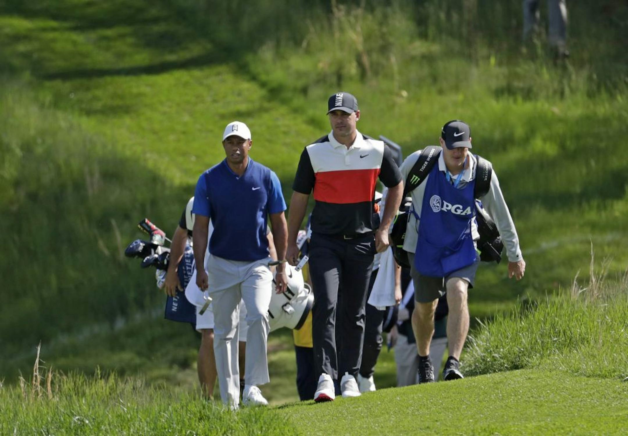 Tiger Woods, left, and Brooks Koepka walk to the 14th fairway during the first round of the PGA Championship golf tournament, Thursday, May 16, 2019, at Bethpage Black in Farmingdale, N.Y.