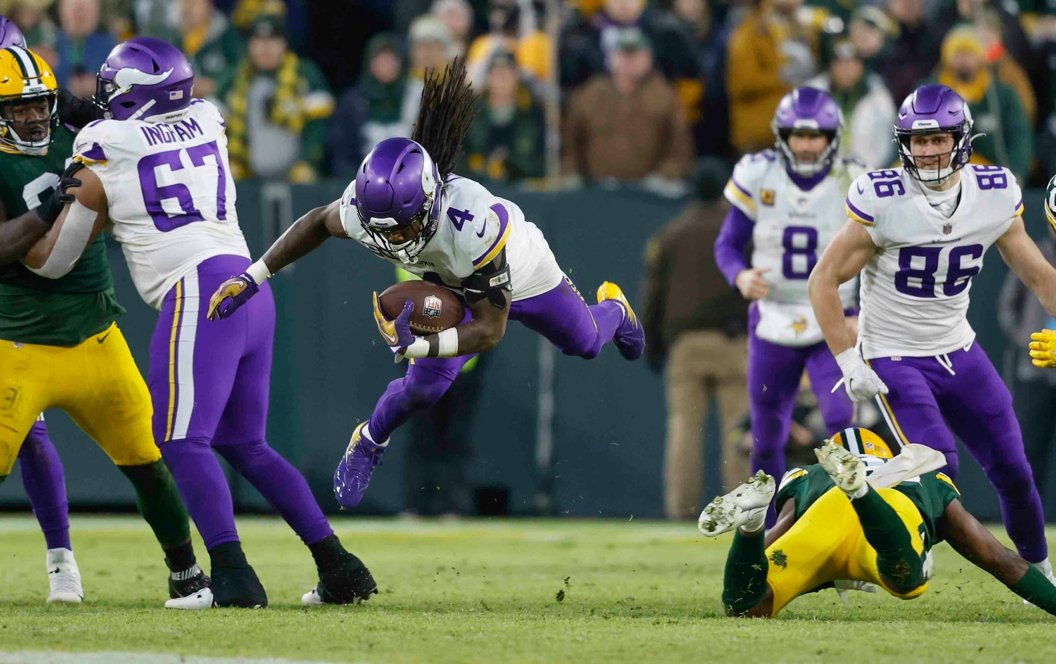 Minnesota Vikings running back Dalvin Cook (4) is tripped up against the Green Bay Packers during an NFL football game Sunday, Jan. 1, 2023, in Green Bay, Wis. (AP Photo/Jeffrey Phelps)