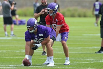 Kirk Cousins takes a snap from rookie center Garrett Bradbury during training camp.