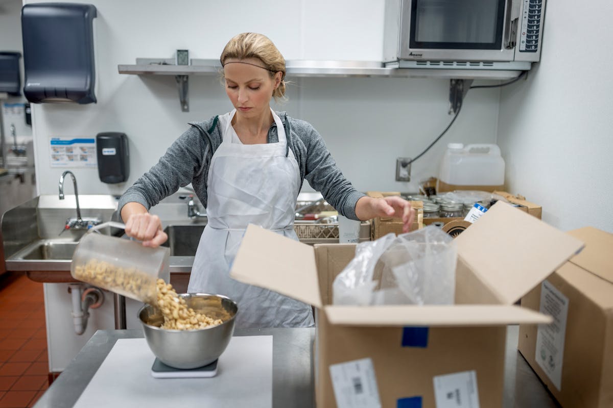 Jessica Waller works on making a cashew peanut butter in an industrial kitchen at the Cornerstone Creek Apartments in Golden Valley. 