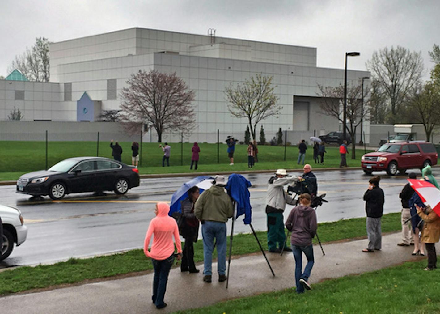 FILE - In this April 21, 2016 file photo, people stand outside entertainer Prince's Paisley Park compound in Chanhassen, Minn. Court filings in Prince's estate show that a special administrator, and likely Prince's siblings, are eager to explore the money-making potential of making a tourist attraction out of his Paisley Park home and studio complex. (Jim Gehrz/Star Tribune via AP, File) MANDATORY CREDIT; ST. PAUL PIONEER PRESS OUT; MAGS OUT; TWIN CITIES LOCAL TELEVISION OUT TV is soft out