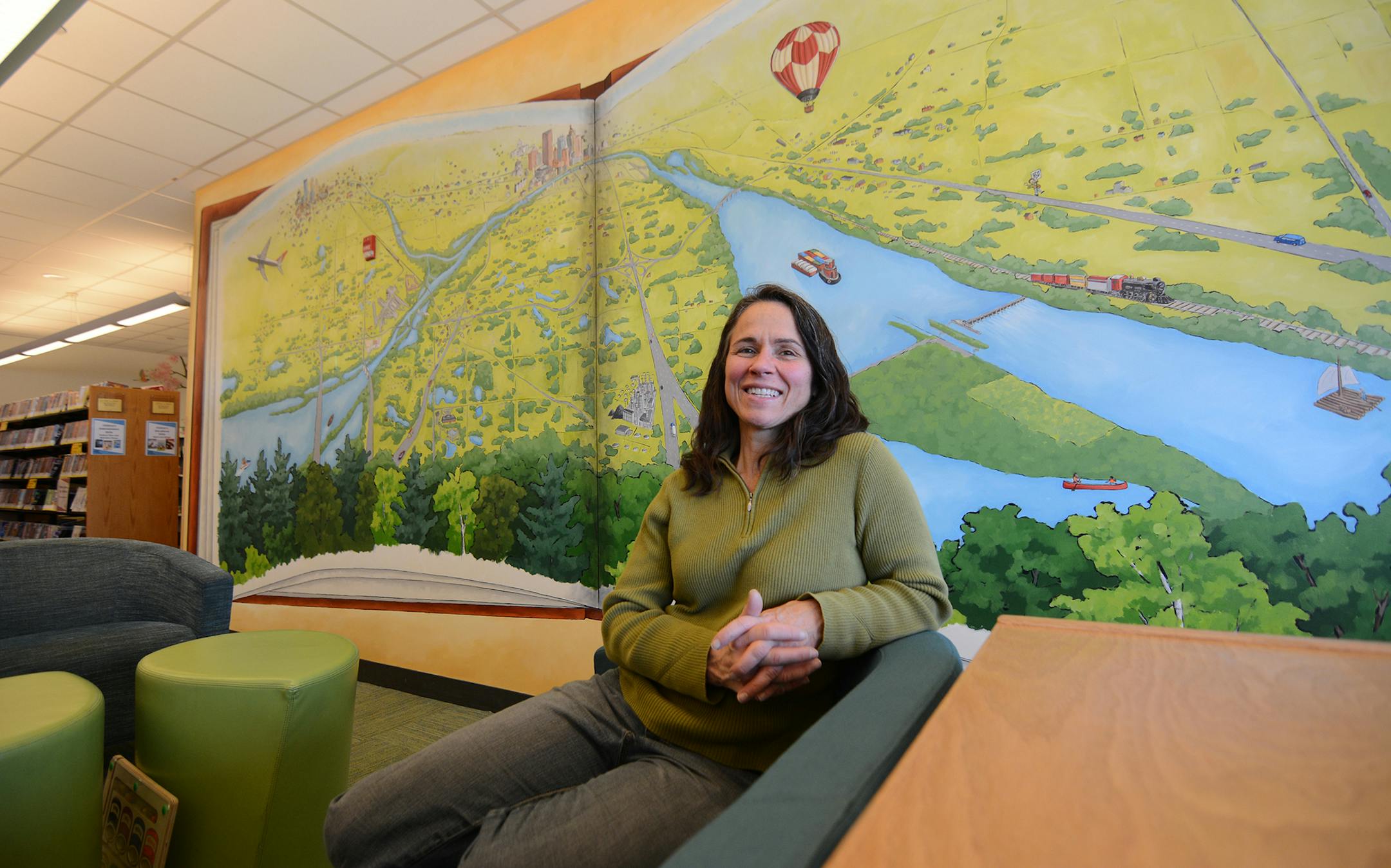 Minneapolis artist Julie Prairie sits in front of a mural she recently completed at Wescott Library in Eagan. Photo by Liz Rolfsmeier, Special to the Star Tribune