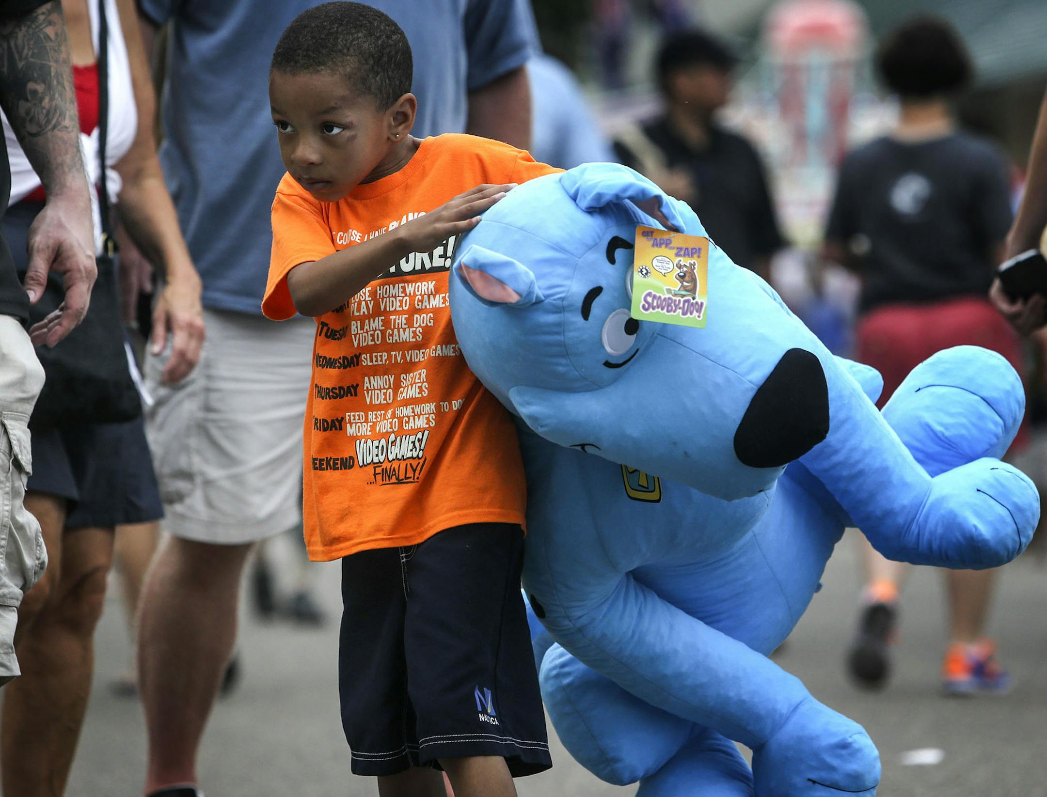 Quilon Young, 6, had the large task of carrying a scooby doo stuffed animal won by his father Jay Burns of Minneapolis during the first day of the Minnesota State Fair Thursday, Aug. 21, 2014 in Falcon Heights, MN.] (DAVID JOLES/STARTRIBUNE) djoles@startribune First day of the Minnesota State Fair Thursday, Aug. 21, 2014 in Falcon Heights, MN.**Quilon Young, Jay Burns,cq