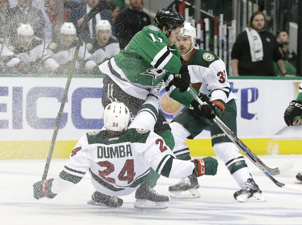 Wild defenseman Matt Dumba was knocked off his feet by Stars center Mattias Janmark as others looked for a route into the action during the first peri