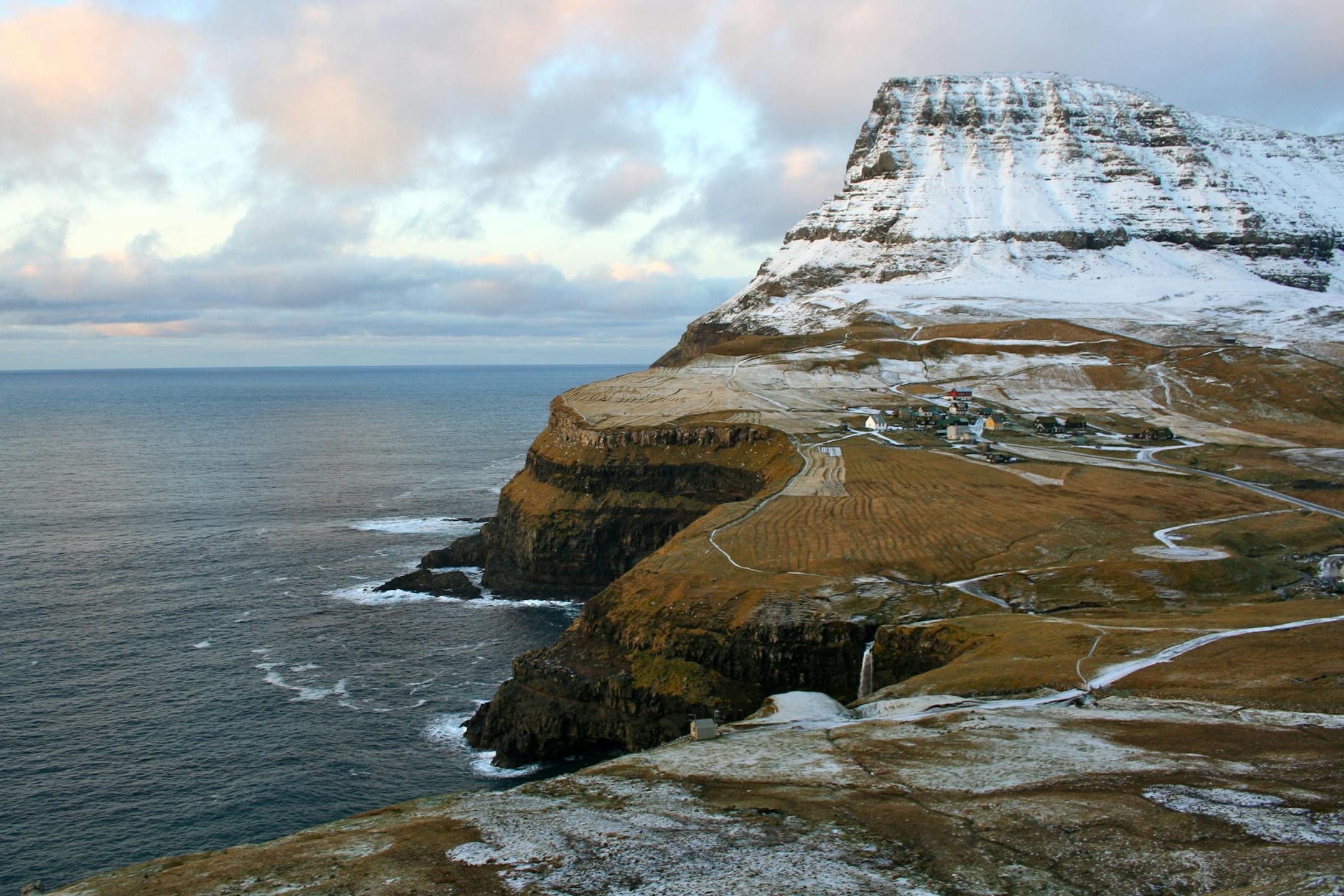 Homes stand in a village on the island of Vagar in the western Faroe Islands, under the sovereignty of Denmark, on Friday, Dec. 7, 2012. A proposed plan would decipher the complete DNA sequence of the 50,000 citizens of this tiny, windswept land halfway between Scotland and Iceland, from its fishermen to the prime minister, using the data for medical treatment and research. Scientists already see the Faroes becoming a model for the use of human genomes. Photographer: John Lauerman/Bloomberg ORG