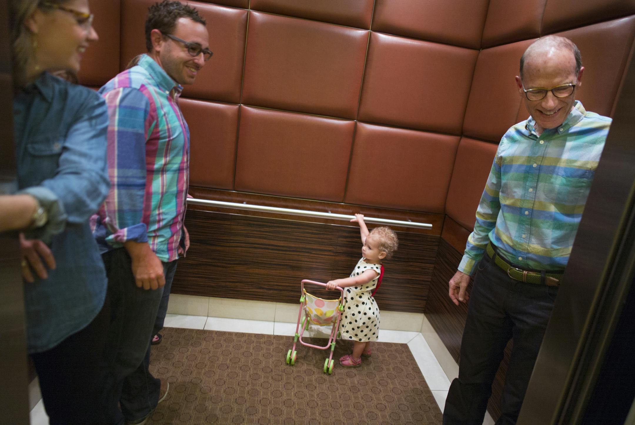 At the Carlyle condo building in downtown Minneapolis, Betsy Kuller and her husband, Ben Gerber, ride the elevator with daughter Rozlyn, 2, and Kuller's father, Hart Kuller. All live in the Carlyle.