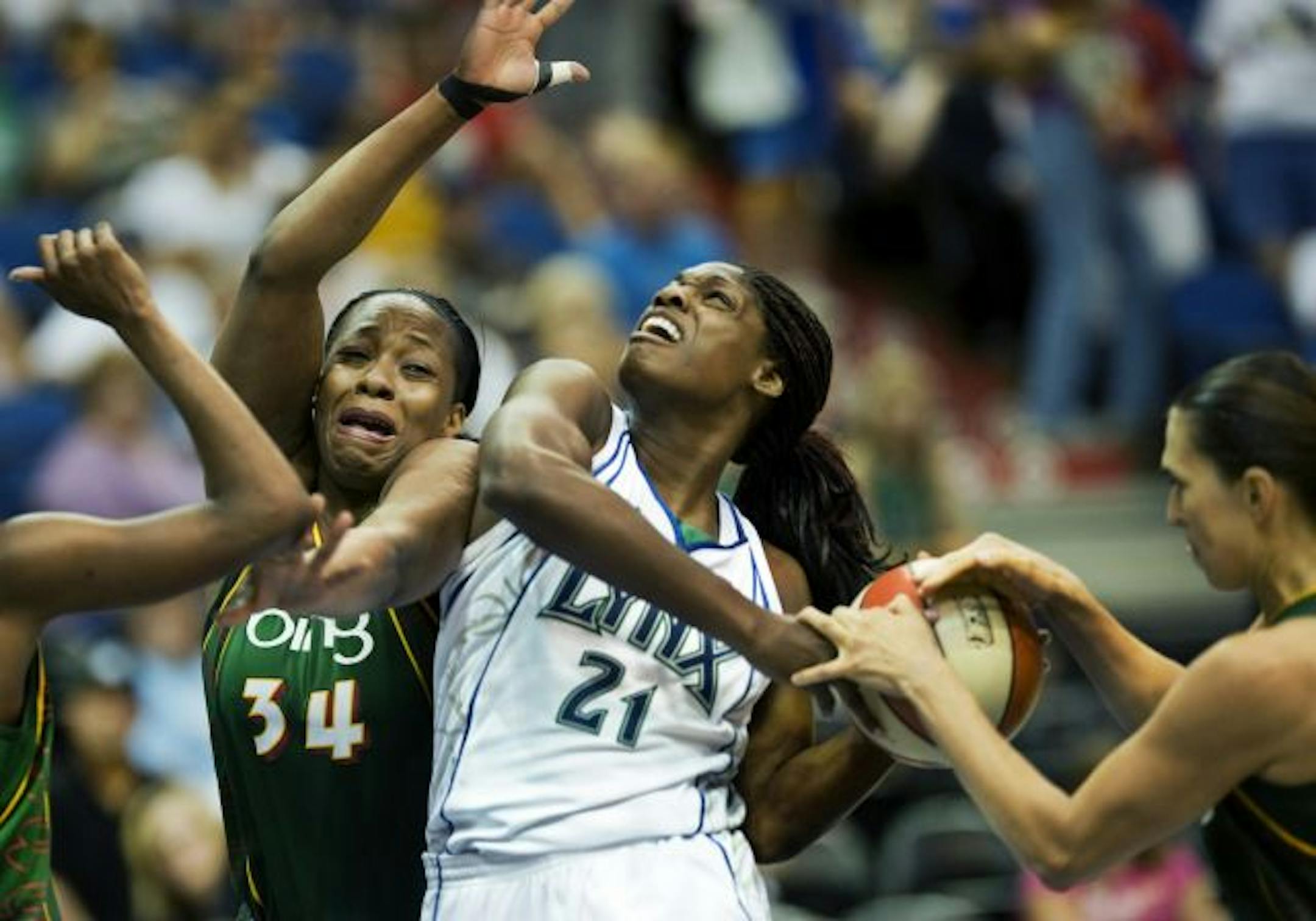 While trying to get a shot off at the basket, Lynx Nicky Anosike was closely guarded by Seattle's Le'coe Willingham (34) and Svetlana Abrosimova.