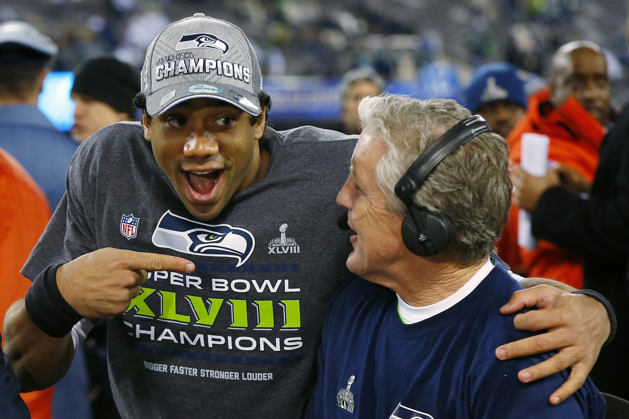 Seattle Seahawks' quarterback Russell Wilson, left, laughs with Seahawks head coach Pete Carroll during a television interview after the NFL Super Bowl XLVIII football game Sunday, Feb. 2, 2014, in East Rutherford, N.J. The Seahawks won 43-8. (AP Photo/Paul Sancya)
