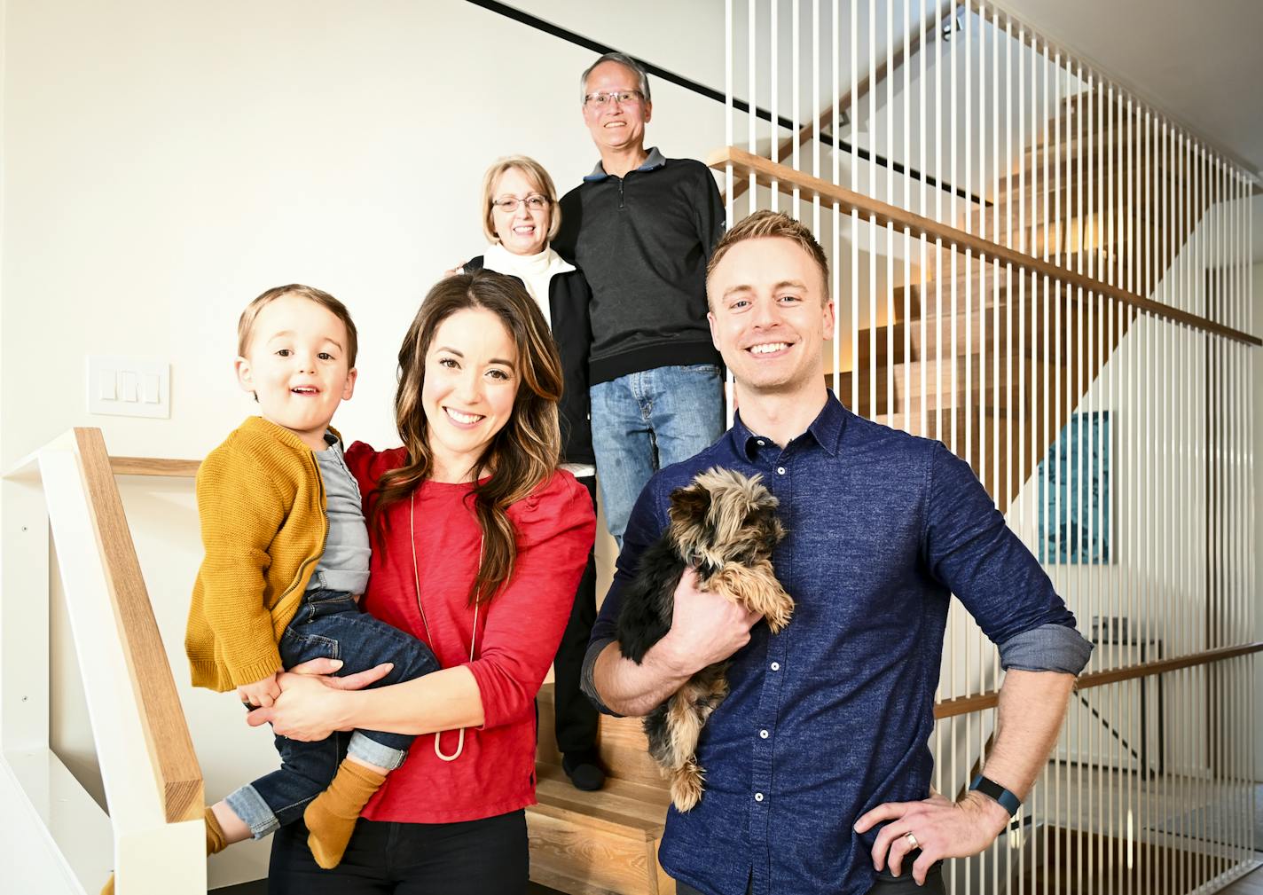 Eric and Stephanie Schafer held their son, Wolf, 2, and their 10-year old Yorkshire terrier, Gus, Friday in their Golden Valley home. Stephanie's parents, Peter and Beth Newland, top, live in the home's lower level.