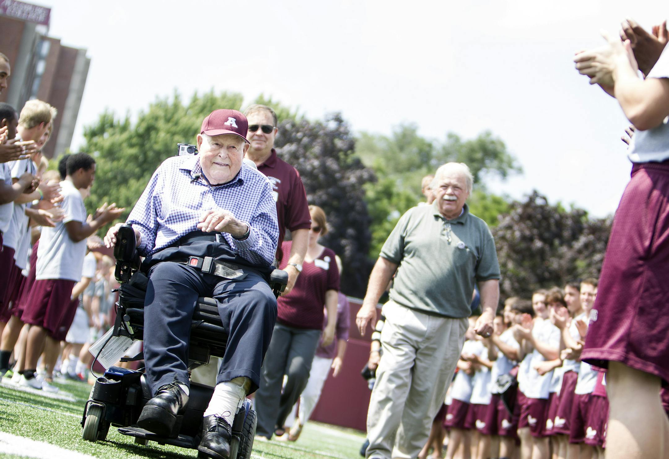 Edor Nelson and his family enter the field through a tunnel of Augsburg athletes at the dedication ceremony for the new scoreboard named in his honor at Augsburg College in Minneapolis August 18, 2014. Nelson also turned 100 years old Monday. (Courtney Perry/Special to the Star Tribune)