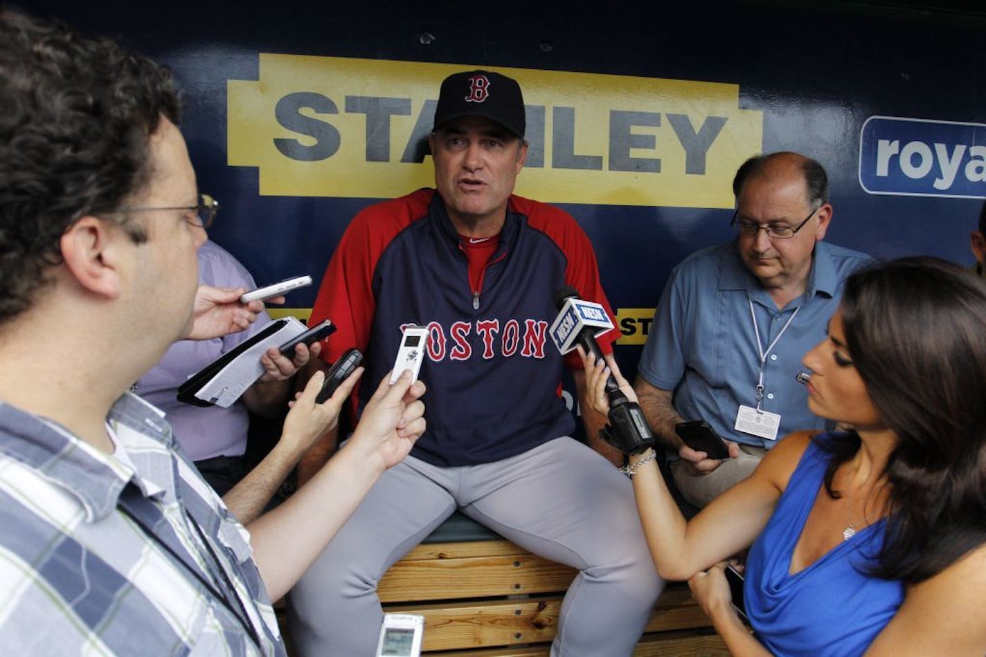 Boston Red Sox manager John Farrell, center, talks to members of the media during batting practice before of a baseball game against the Kansas City Royals at Kauffman Stadium in Kansas City, Mo., Thursday, Aug. 8, 2013.