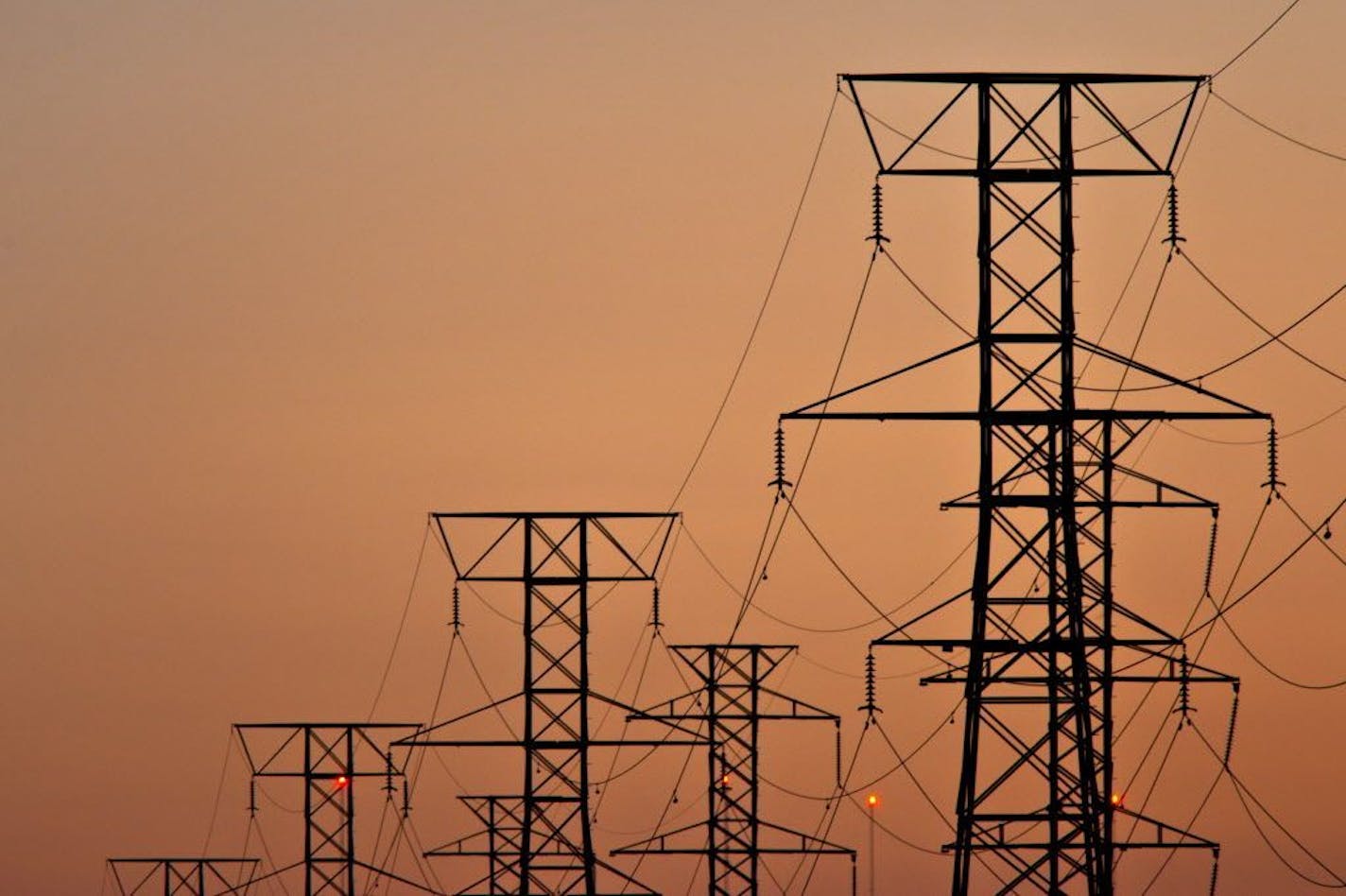 Power transmission lines are suspended from electricity pylons in Kearny, New Jersey, U.S., on Thursday, Aug. 26, 2010. U.S. electrical output rose 6.2 percent to 94,254 gigawatthours from a year earlier during the week ending Aug. 14. About 45 percent of U.S. electricity will come from coal plants and 22 percent from natural gas power facilities this year, according to the Energy Department. Photographer: Steve Hockstein/Bloomberg