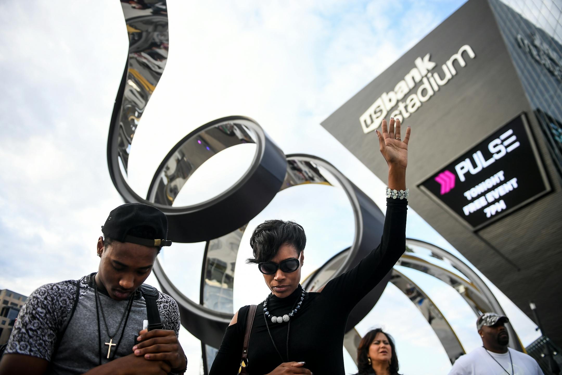 Mariaha Dean, and her son Tytist, 17, or Rosebille, bowed their head in prayer during Thursday night's faith-based gathering outside US Bank Stadium in Minneapolis.