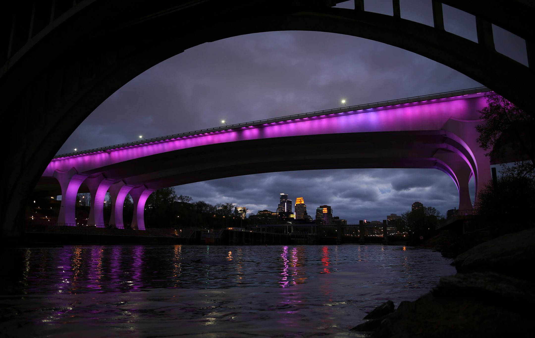 The I-35W bridge was bathed in purple Thursday night in a memorial to Prince. ] JEFF WHEELER • jeff.wheeler@startribune.com Downtown Minneapolis buildings were bathed in purple light, including the I-35W bridge, foreground, in a memorial to Prince Thursday, April 21, 2016.