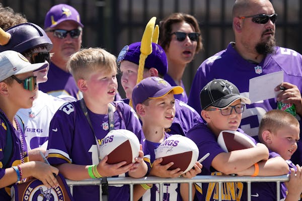 Kolby Clarine, left, and his friend Carver Clough, both 10, both of Brainerd, wait for autographs as the Vikings held training camp Saturday, July 30,