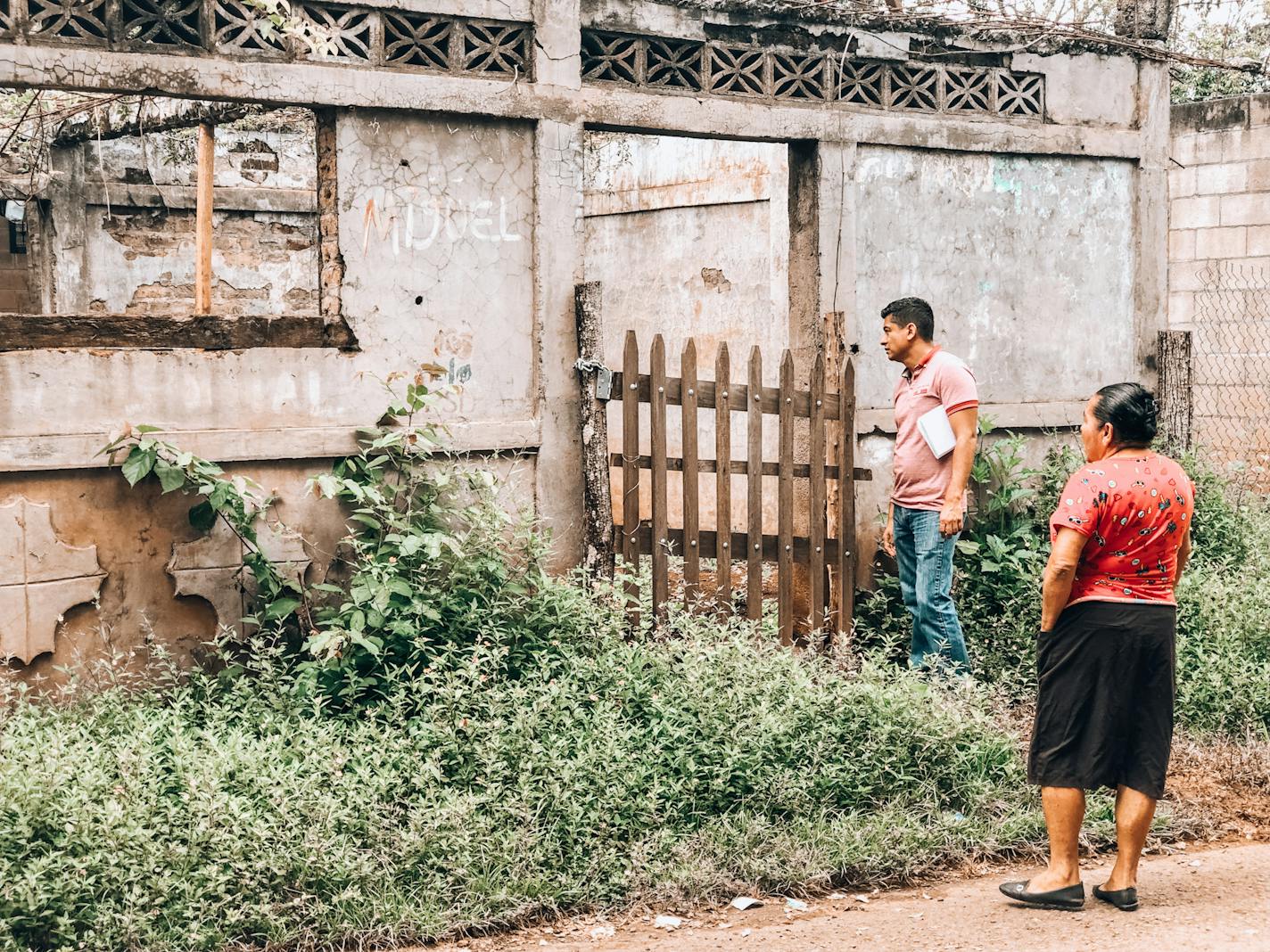 Maria Delfina Argueta and a man identified as Luis peered into the remains of a house that was destroyed in the 1981 El Mozote massacre in El Salvador.