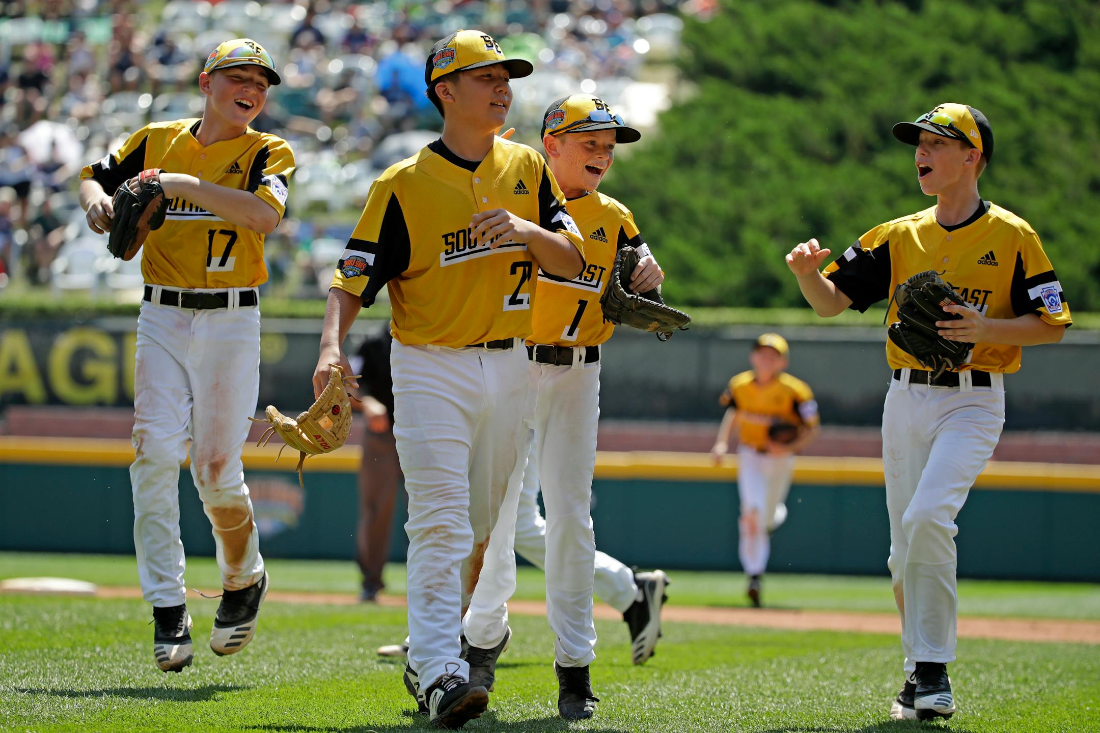 South Riding, Virginia pitcher Justin Lee (22) celebrates as he walks off the field with Chase Obstgarten, left, Matt Coleman (1), and Colton Hicks (9) getting the final out of the fourth inning and an 11-0 win over Coon Rapids, Minnesota in a baseball game at the Little League World Series tournament in South Williamsport, Pa., Sunday, Aug. 18, 2019. Lee allowed no hits in the contest. (AP Photo/Gene J. Puskar)