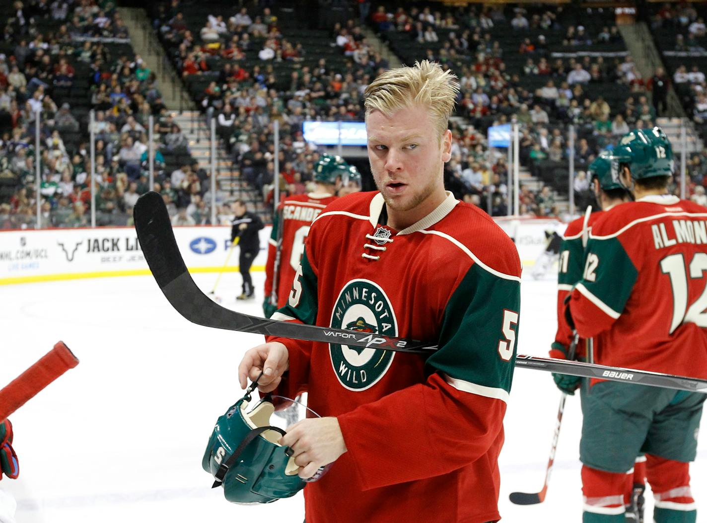 Minnesota Wild defenseman Christian Folin puts on his helmet during the second period of a preseason NHL hockey game against the Pittsburgh Penguins in St. Paul, Minn., Monday, Sept. 29, 2014. (AP Photo/Ann Heisenfelt)