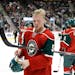 Minnesota Wild defenseman Christian Folin puts on his helmet during the second period of a preseason NHL hockey game against the Pittsburgh Penguins i