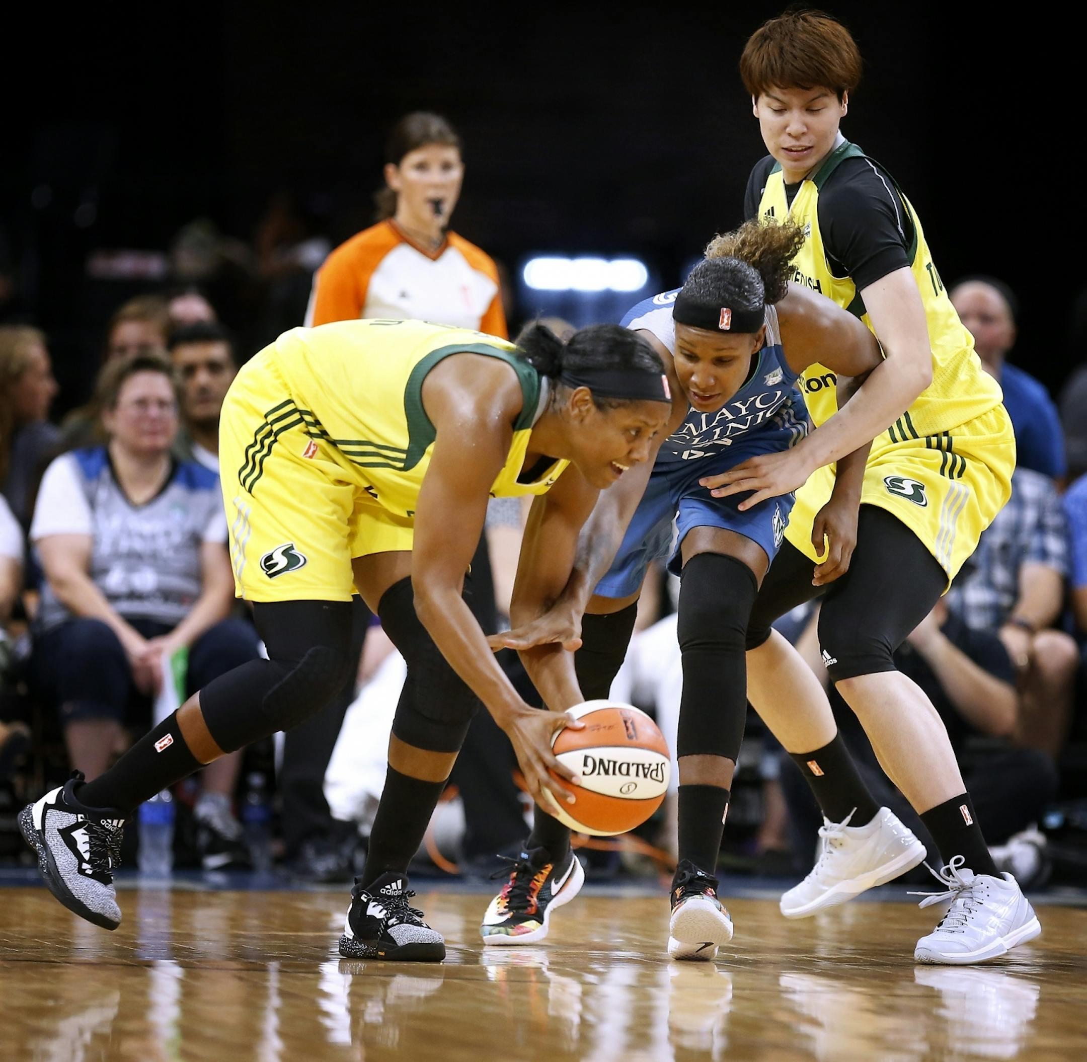 Minnesota Lynx forward Rebekkah Brunson (32) has the ball stolen from her by Seattle Storm guard Noelle Quinn (45), left, as Seattle Storm forward Ramu Tokashiki (7), right, defends during the first half.