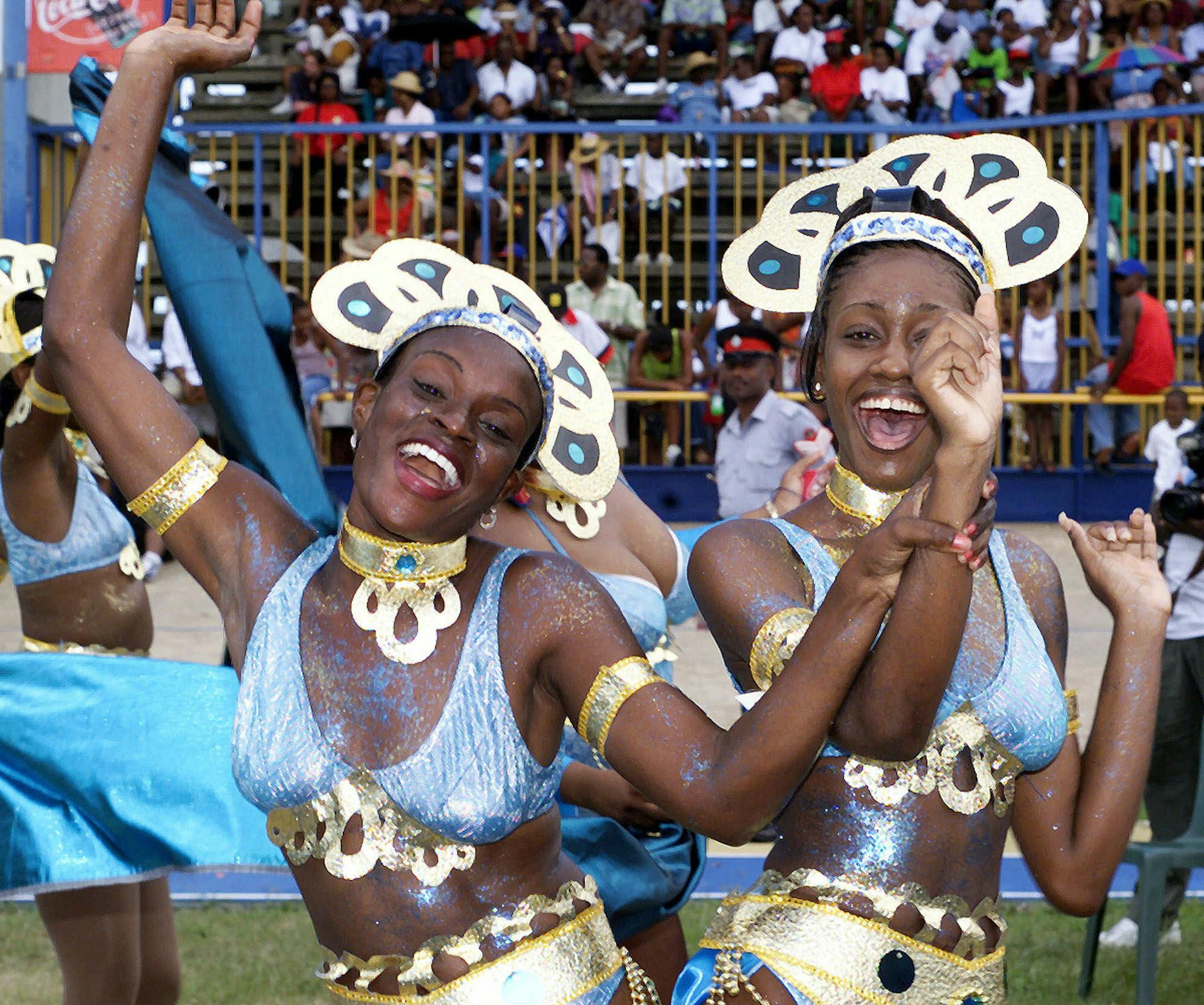 Two unidentified revelers dance during the Kadooment Parade in Bridgetown, Barbados, Monday, August 2, 1999. The Kadooment Day Parade is an annual event in Barbados, when thousands of participants take to the streets wearing costumes and dancing to calypso music. (AP Photo/Chris Brandis) ORG XMIT: BRB101