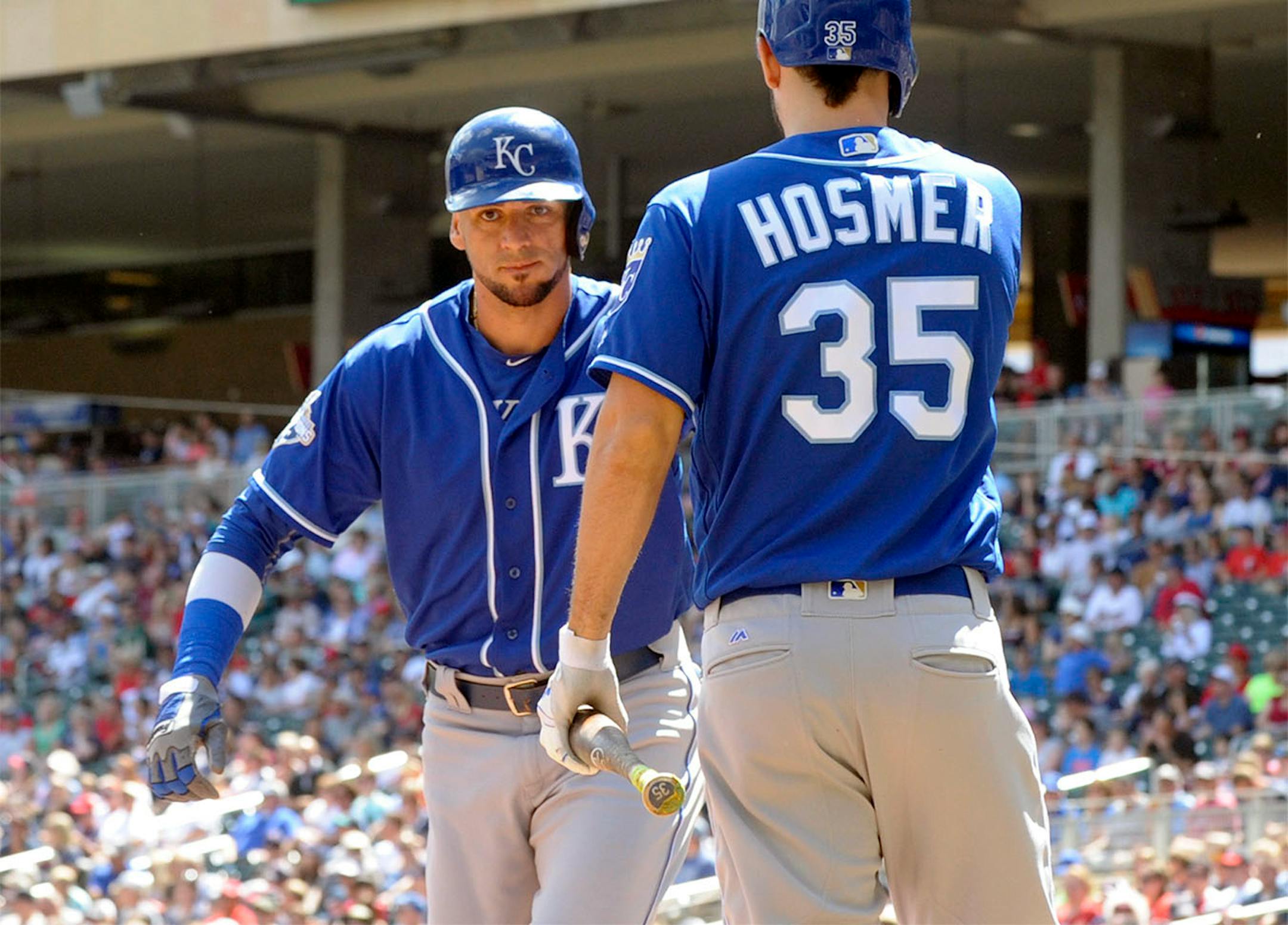 Kansas City Royals' Eric Hosmer (35) congratulates teammate Paulo Orlando, left, after Orlando scored on a sacrifice fly in the first inning of a baseball game against the Minnesota Twins, Sunday, Aug. 14, 2016, in Minneapolis.