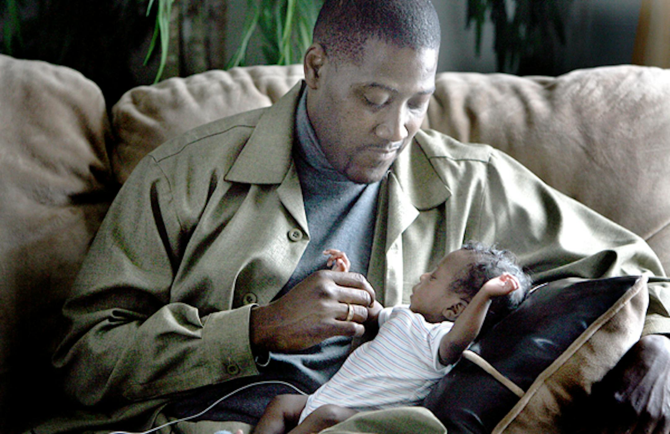 Fredrick Wilson held his 2-month-old grandson, Quentin, in the living room of a home that he and his wife, Annette, rent in Otsego. The Wilsons face eviction because a rent-to-own program fell through.