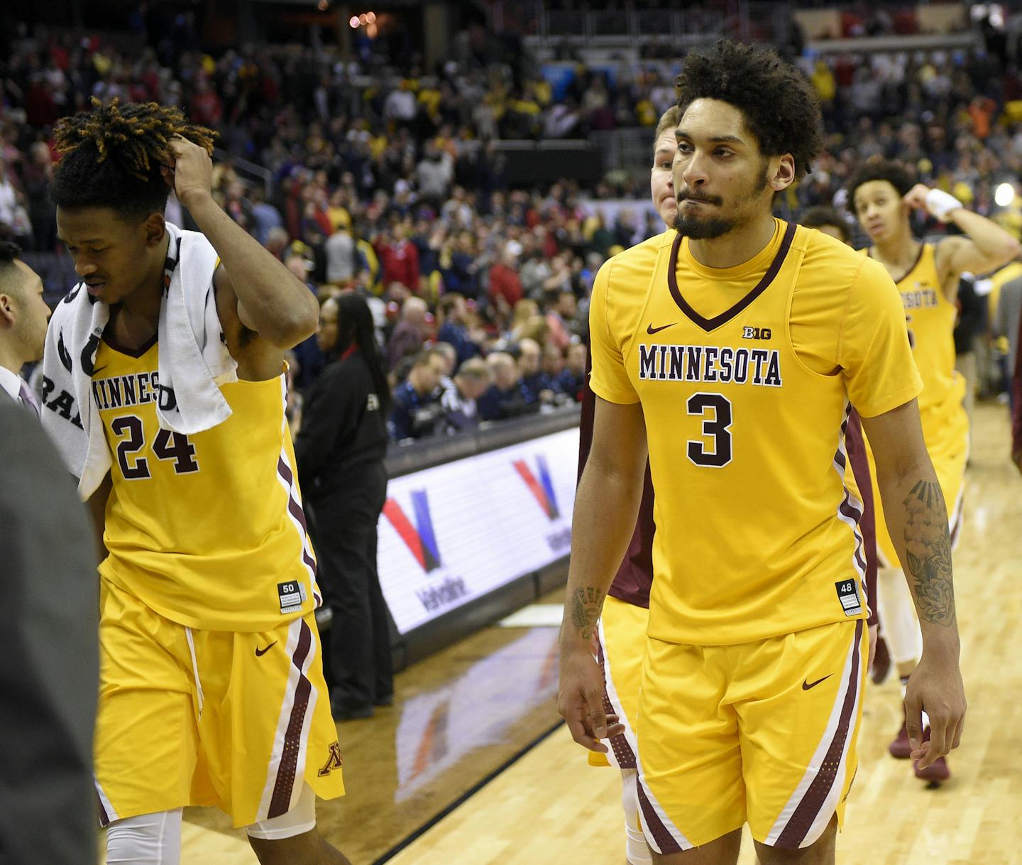 Minnesota's Eric Curry (24), Jordan Murphy (3) and others leave the court after an NCAA college basketball game against Michigan in the Big Ten tournament, Saturday, March 11, 2017, in Washington. Michigan won 84-77. (AP Photo/Nick Wass)