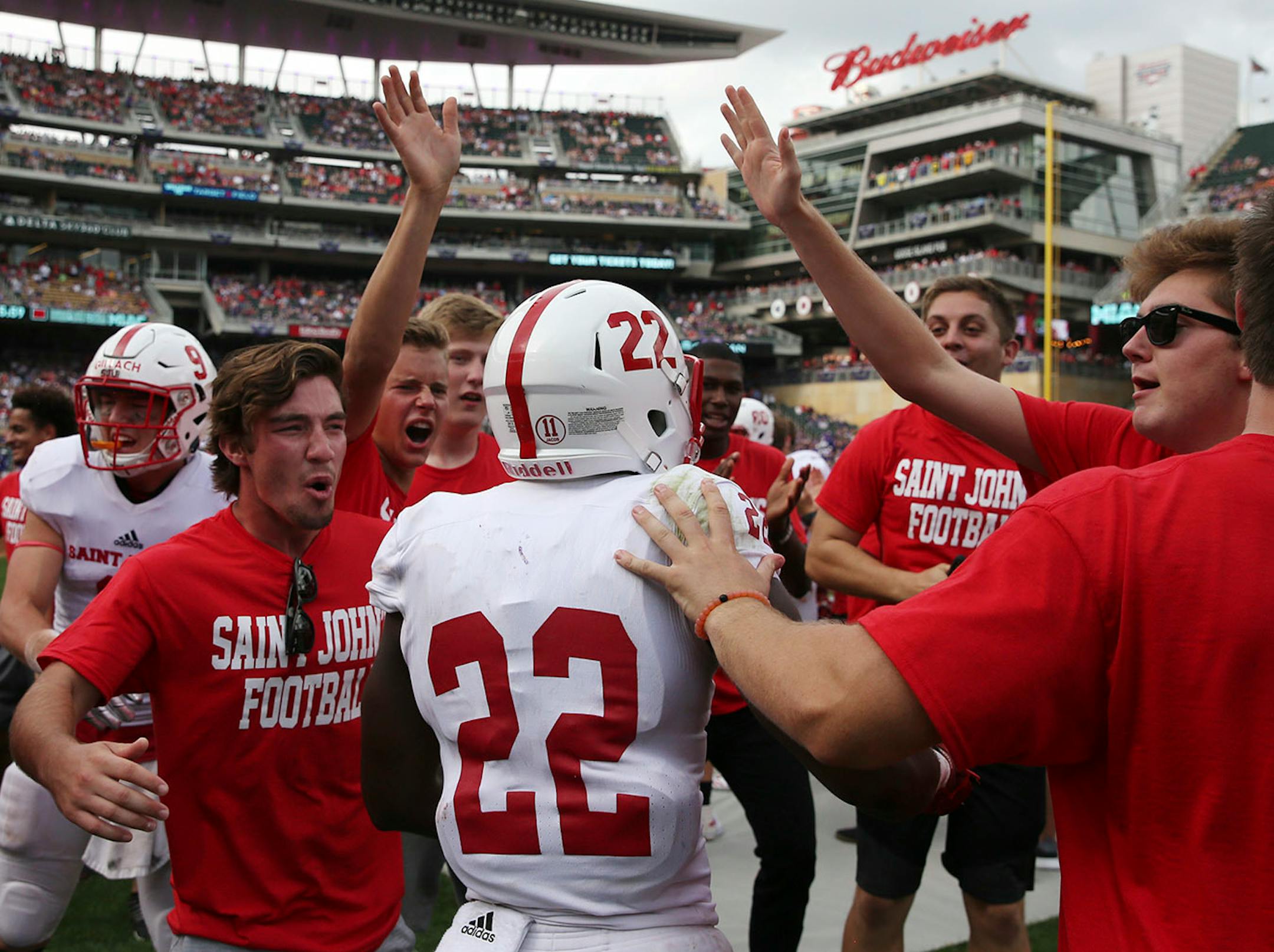 St. John's University wide receiver Evan Clark (22) was congratulated by his teammates after scoring a touchdown in the second half.
